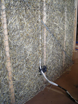 Internal stuffed strawbale wall with electrical rough-in visible.