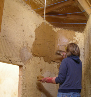 Applying the final coat of straw bale render using a trowel.